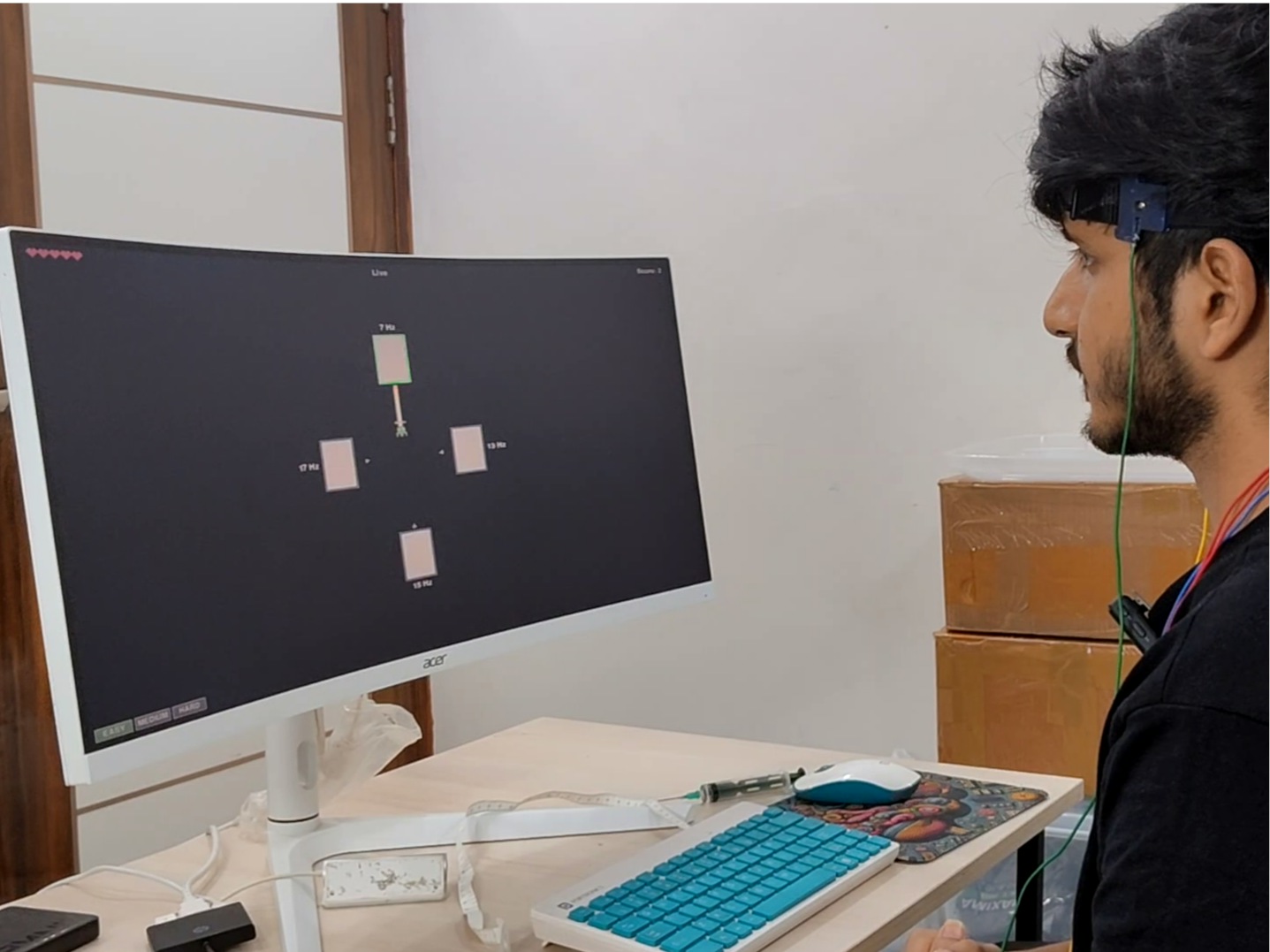 Person wearing NPG Lite with occipital electrodes, playing an SSVEP-controlled game